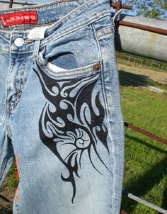 a pair of jeans with an image of a cat painted on them