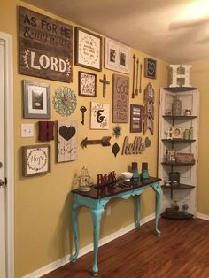 a room with yellow walls and lots of pictures on the wall, including a blue table