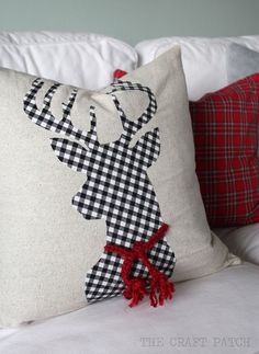 a pillow with a deer on it and a red pom - pom in the corner