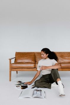 a woman sitting on the floor next to a couch