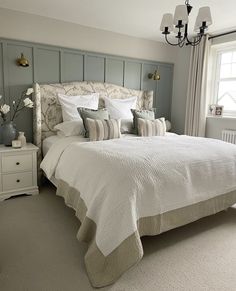 a bedroom with a bed, dressers and window in it's center area