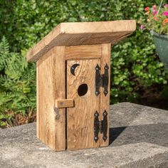 a wooden birdhouse sitting on top of a rock