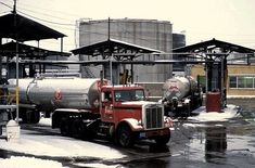 a red and white truck parked in front of a building on a snowy day with lots of power lines