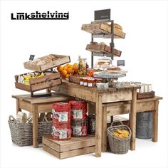 an assortment of food is displayed on wooden tables with baskets and bins next to them