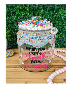 a jar filled with lots of sprinkles on top of a wooden table