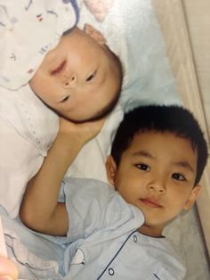 two young boys laying next to each other