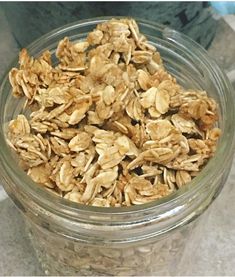 a glass jar filled with granola sitting on top of a counter