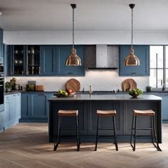 Modern kitchen with blue cabinets, brass pendant lights, and a large island with three wooden bar stools. Line Kitchen, Trendy Kitchen Colors