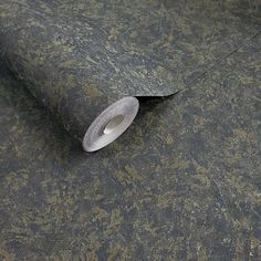 a roll of metallic foil sitting on top of a carpet covered in brown and gold flecks