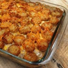 a casserole dish with potatoes and carrots in it on a wooden table