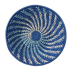 a blue and white basket with an intricate design on the bottom, in front of a white background