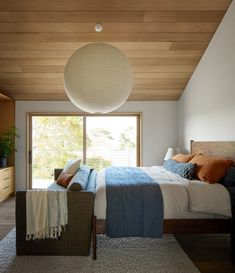 a bedroom with a large bed and wooden ceiling