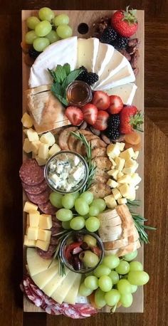 a platter filled with cheese, fruit and crackers