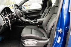 the interior of a blue truck with black leather seats