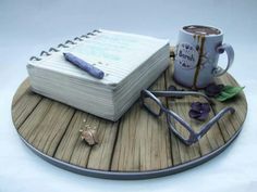 a wooden tray with a notebook, pen and eyeglasses sitting on top of it