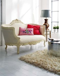 a living room with a white couch and painting on the wall above it's head