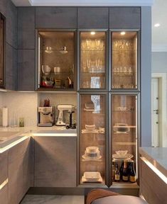 a kitchen with grey cabinets and glass doors