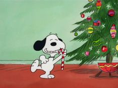 a cartoon dog holding a candy cane in front of a christmas tree