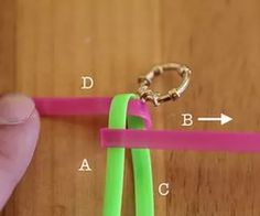 a pair of pink and green plastic scissors being held by a person's hand