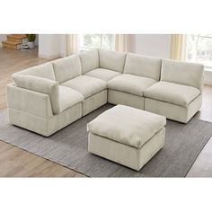 a living room with a sectional couch and ottoman