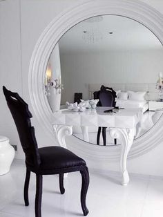 a white table and chair in front of a large mirror with the words, justfoodmassay below it