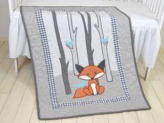 a baby bed with a blanket that has a fox on it