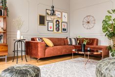 a living room filled with lots of furniture next to a wall mounted art piece on the wall