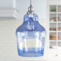 a blue glass light hanging from a kitchen ceiling