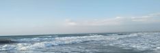 a person riding a surfboard on top of a wave in the ocean near shore