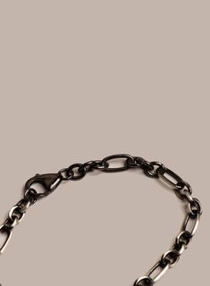 A very unique Satin Black Rhodium plating over sterling silver that shows the silver underneath and gives it a worn in look. With a 3 to 1 circle to val link reminiscent of a Figaro chain pattern this modern and elegant chain bracelet is the perfect bracelet two wear by itself to to stack with a few others. Link Width: 6mm Material: Satin Rhodium Plating over 925 Sterling Silver Clasp: Lobster Claw. Available in size 7in, 8in and 9 inches. Feel free to contact us for other custom sizes. Made in Stainless Bracelet, Chain Pattern, Figaro Chain, Black Rhodium, Cord Bracelets, Modern Jewelry, Men Necklace, Gemstone Necklace, Lobster Claw