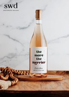 a bottle of wine sitting on top of a wooden cutting board next to some nuts