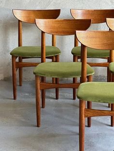 four wooden chairs with green upholstered seats