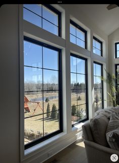 a living room filled with furniture and large windows