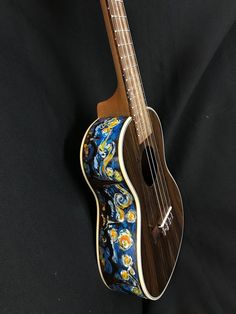 a ukulele with a blue and yellow flower design on it