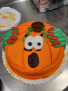 a cake decorated like a pumpkin with googly eyes and nose for decoration on a table