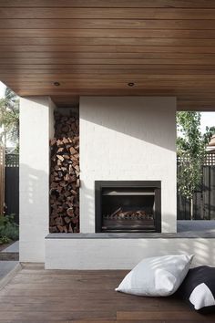 an outdoor fireplace with wood stacked on top