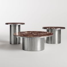 three tables with marble tops and metal bases