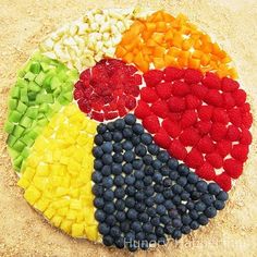 a plate with different colored fruits and vegetables in the shape of a rainbow on it