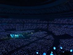 an aerial view of a concert venue at night with blue lights on the floor and in the ceiling