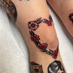 two people with tattoos on their legs and one is wearing a flowered heart tattoo