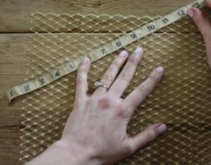 a woman is measuring her nails with a tape measure on top of a piece of fabric