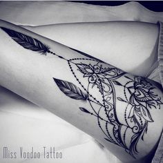 black and white photo of a woman's leg with tattoos on it, showing her legs