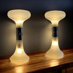 two lamps sitting on top of a wooden table