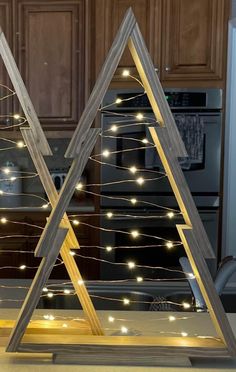 two wooden christmas trees sitting on top of a kitchen counter