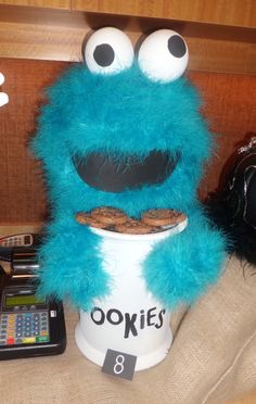 a cookie monster sitting on top of a coffee cup