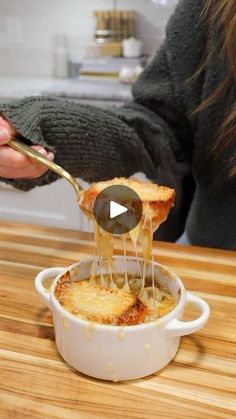 a woman is spooning some food out of a casserole dish