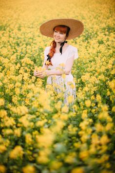 a woman wearing a hat in a field of yellow flowers