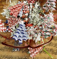 paper christmas trees sit on top of sheet music and are ready to be used as decorations