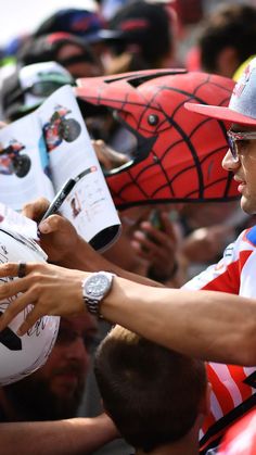 a man signing autographs for fans at a sporting event