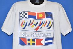 a white t - shirt with the word st thomas printed on it and various flags